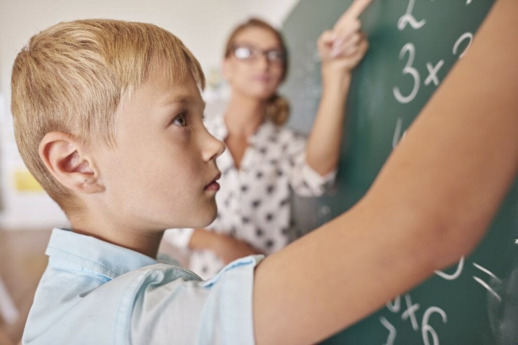 Student learning math at chalkboard