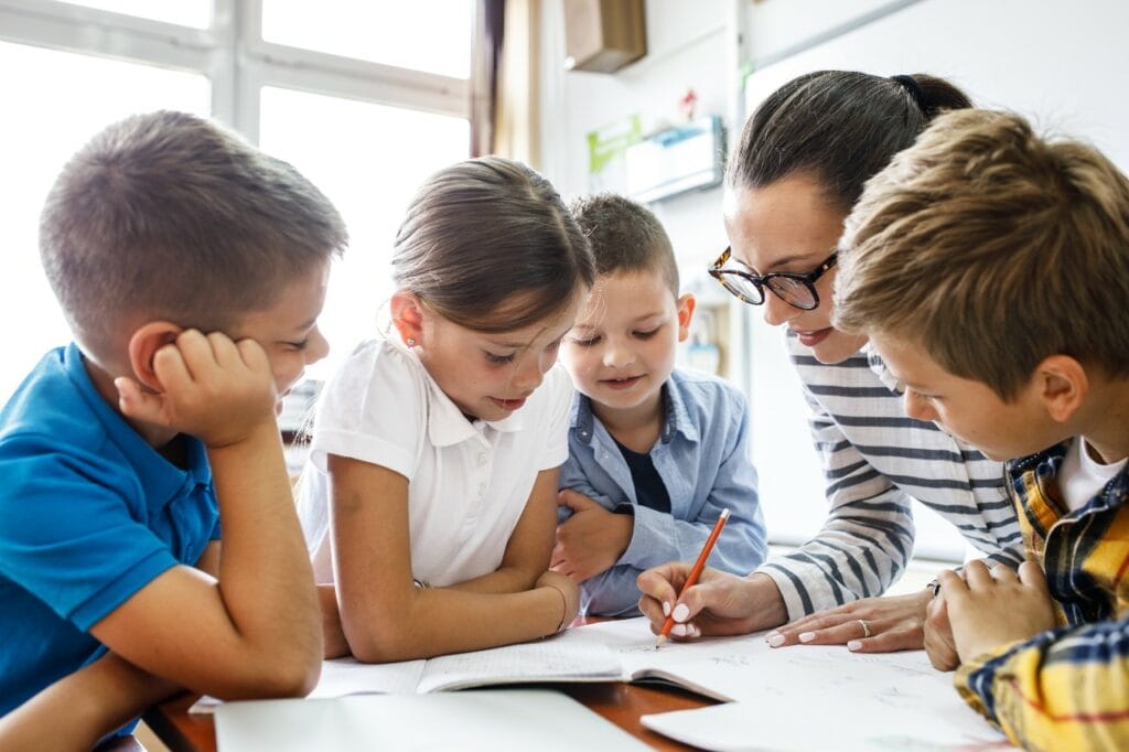 Teacher instructing with students gathered around
