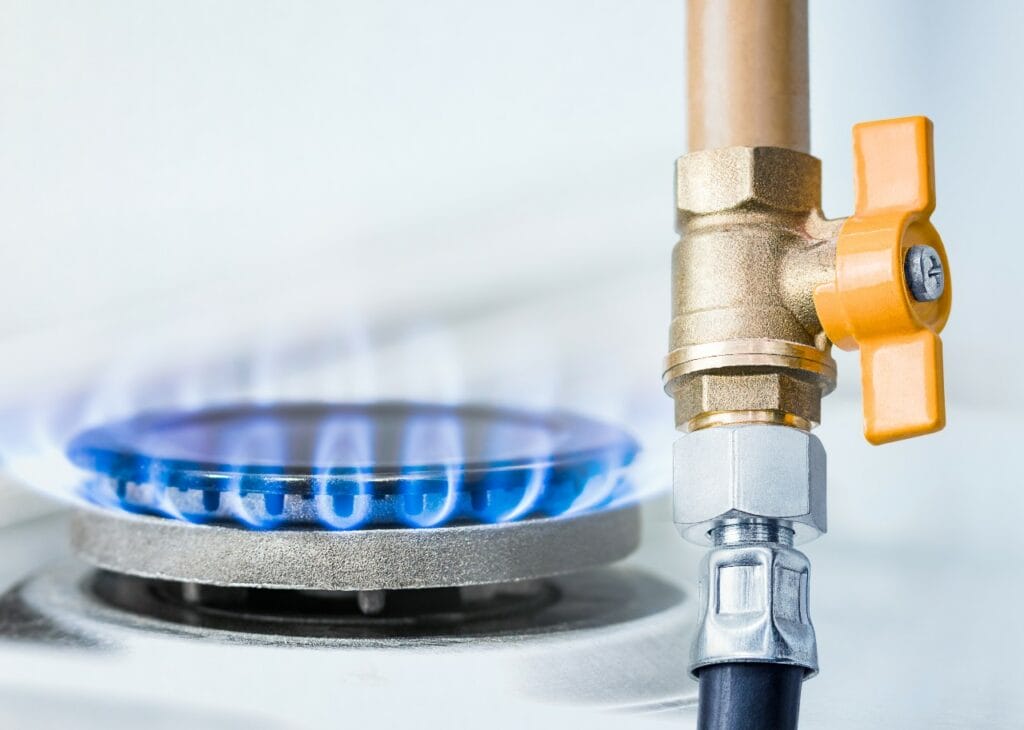 Ignited gas stove with a natural gas valve in the foreground